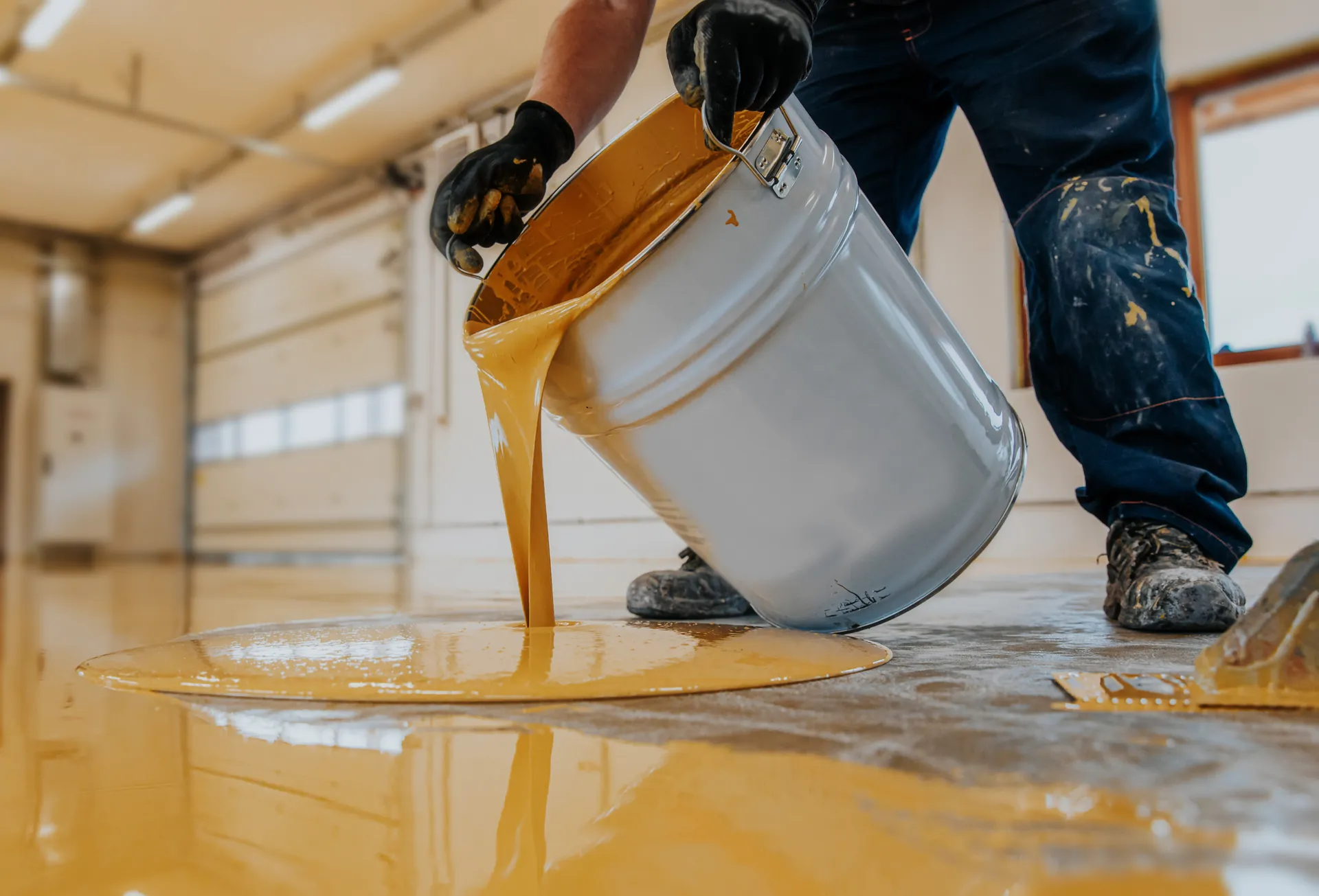 Garage Epoxy 407 installer pouring a protective floor coating
